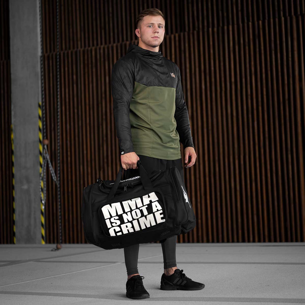 Phantom Athletics Tactic Gymbag mit MMA-Is-Not-a-Crime-Statement – die langlebige Tasche mit gepolstertem Schulterriemen, Karabinern und zahlreichen Innen- und Außenfächern bietet Ordnung bei jedem Training. Ideal für Fitness, Cross-Workouts oder Kampfsportreisen.