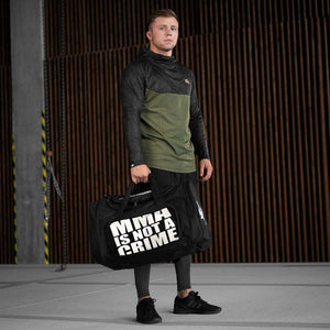 Phantom Athletics Tactic Gymbag mit MMA-Is-Not-a-Crime-Statement – die langlebige Tasche mit gepolstertem Schulterriemen, Karabinern und zahlreichen Innen- und Außenfächern bietet Ordnung bei jedem Training. Ideal für Fitness, Cross-Workouts oder Kampfsportreisen.