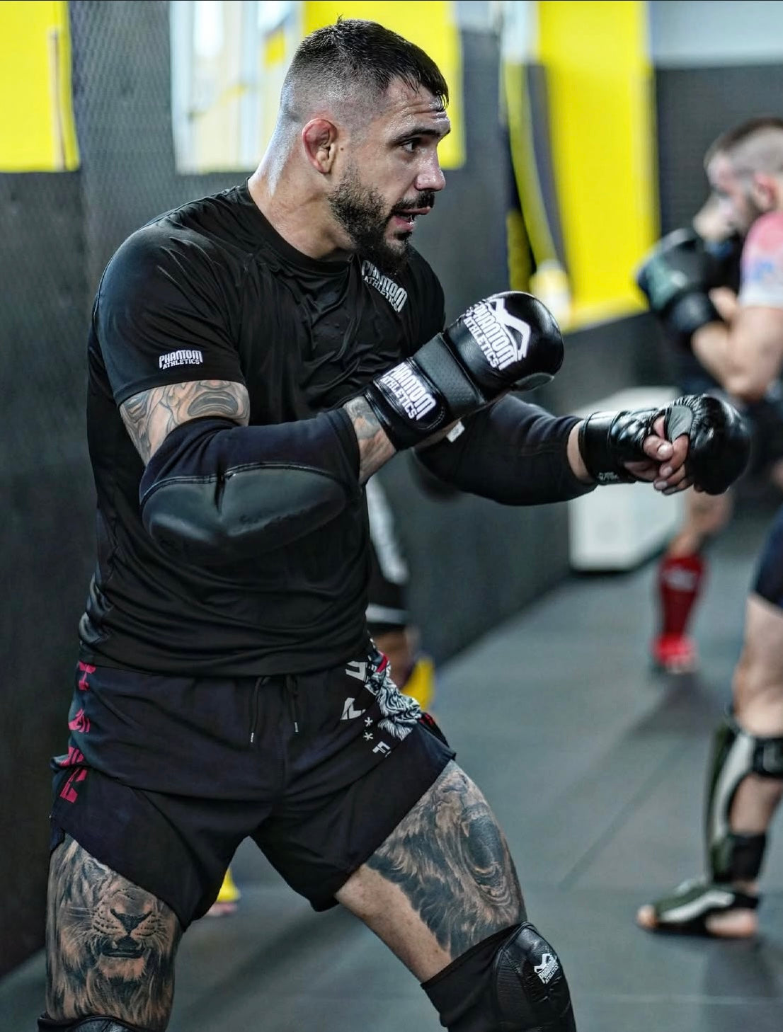 UFC-Fighter Aleksandar "Rocket" Rakic mit Phantom Athletics Rashguard, Training Shorts, Ellbogenschutz, Knieschutz und MMA Gloves