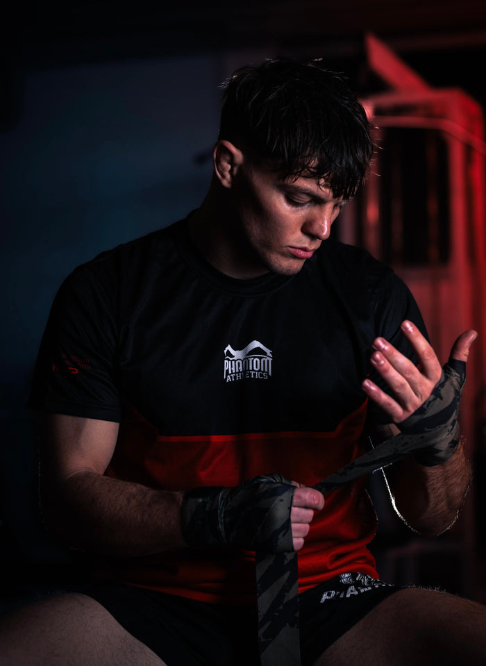 Mixed Martial Arts (MMA)-Fighter Dominik Laritz mit Phantom Athletics Rashguard, Fight Shorts und Boxbandagen