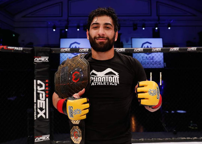 Mixed Martial Arts (MMA)  Fighter Agy Sardari mit Phantom Athletics T-Shirt und dem Weltmeistergürtel  von Cage Warriors