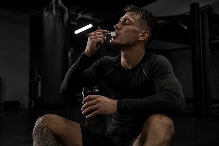 Kampfsport-Athlet im Gym, der gerade Kollagenpeptide zu sich nimmt