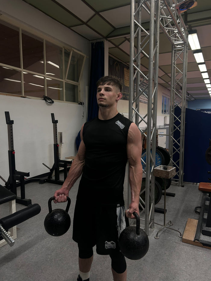 Ringer Manuel Wagin mit Phantom Athletics Tanktop, Training Shorts und Tights während dem Krafttraining