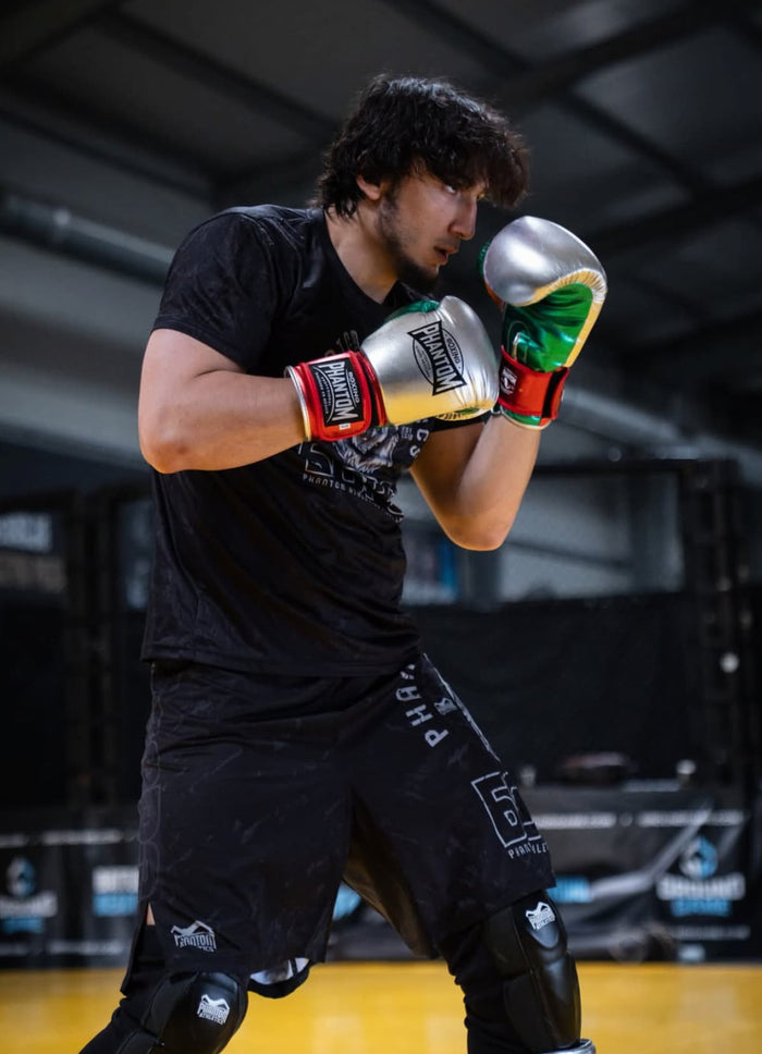 MMA-Fighter Belal Gadamauri mit Phantom Athletics Boxhandschuhen Mexico, T-Shirt, Fight Shorts und Knieschutz im Training