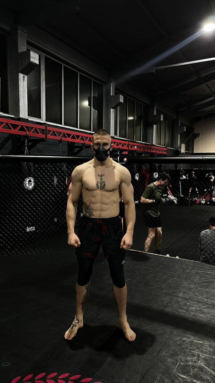 MMA-Fighter David Piechazcek mit Phantom Athletics Trainingsmaske und Fightshorts im Gym