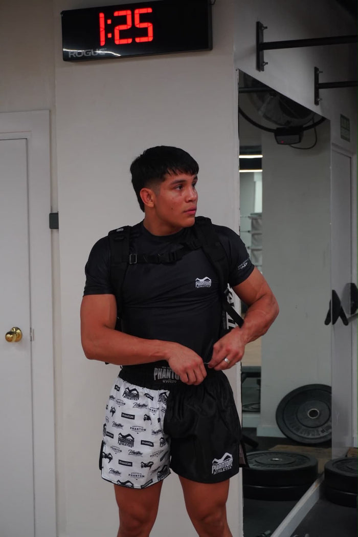 MMA-Fighter Henry Escalona mit Phantom Athletics Rashguard, Fight Shorts und Rucksack im Gym nach dem Training