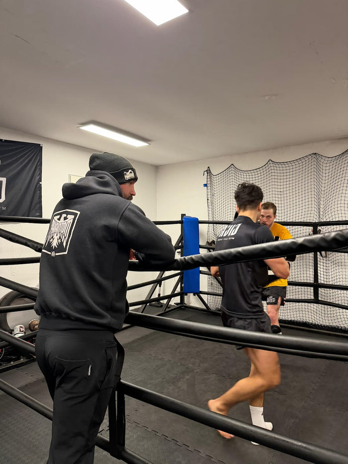 Muay Thai Kämpfer Carsten Ringler mit Phantom Athletics Hoodie, Jogginghose und Mütze als Coach im Gym