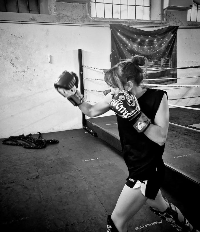 Muay Thai Fighter Kincso Olah mit Phantom Athletics Tanktop, Fightshorts, Boxhandschuhen und Schienbeinschutz im Training