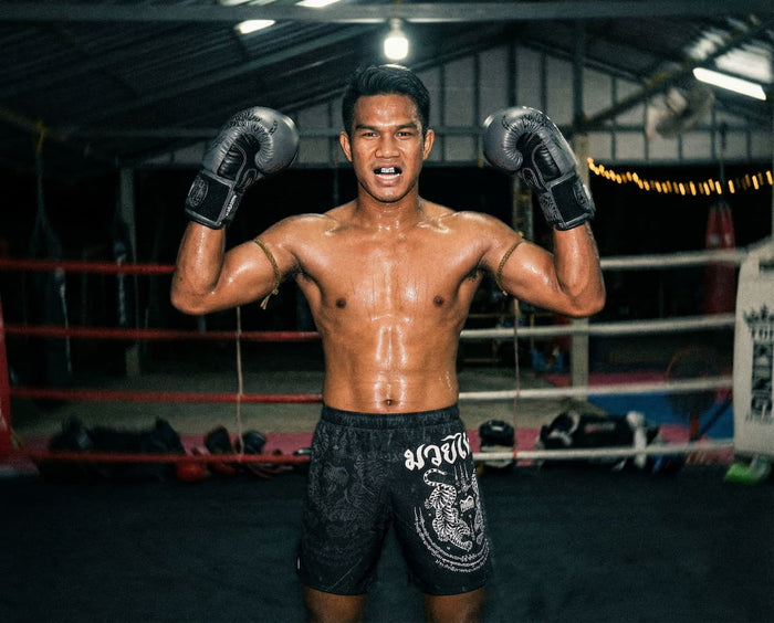 Muay Thai Fighter mit Phantom Athletics Muay Thai Shorts, Muay Thai Boxhandschuhen und Zahnschutz im Gym in Thailand