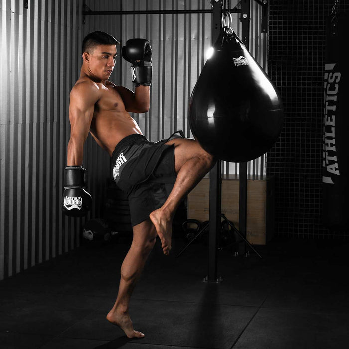 Kampfsport-Athlet mit Phantom Athletics Training Shorts und Boxhandschuhen während dem Training am Boxsack Hydro
