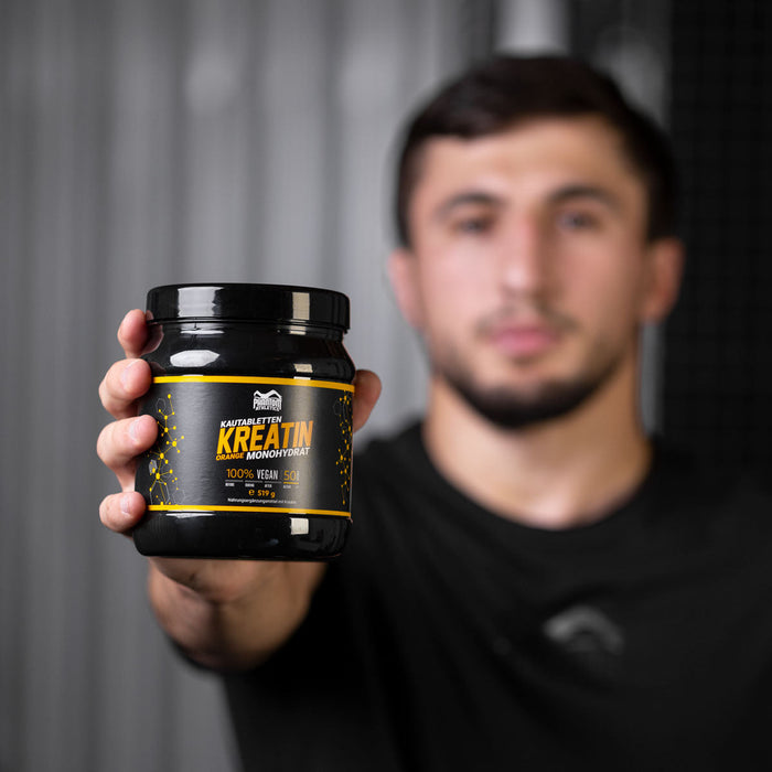 Ringer Idris Ibaev mit Phantom Athletics T-Shirt und Kreatin Kautabletten