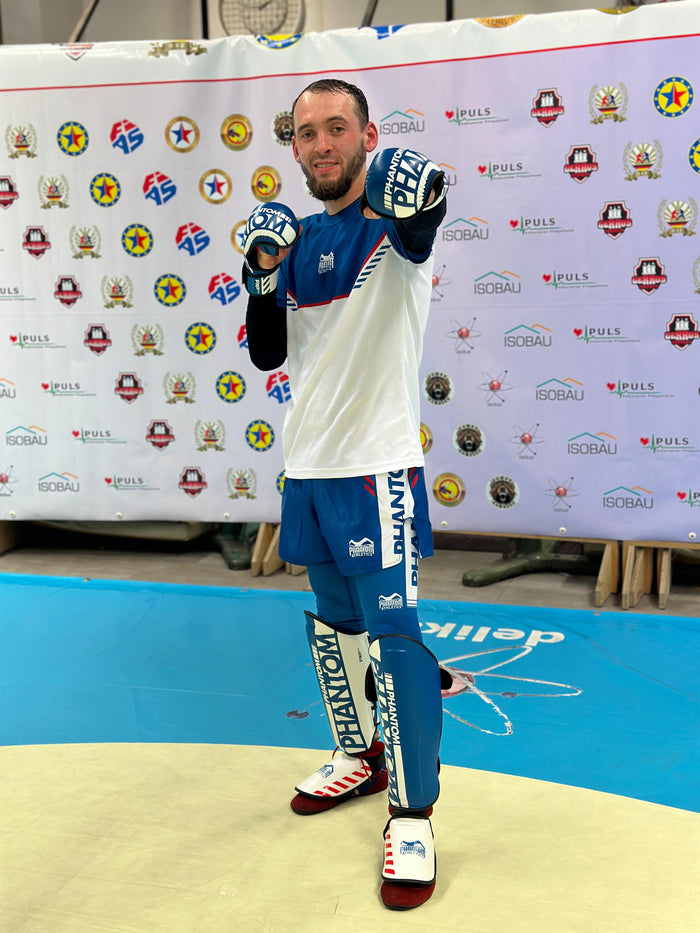 Sambo-Fighter Aset Askarov mit Phantom Athletics Rashguard, T-Shirt, Tights, Training Shorts, Schienbeinschutz und Sparring Gloves kurz vor einem Kampf