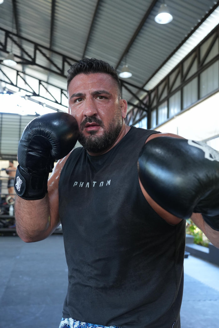 Ringer Ugur Dogan mit Phantom Athletics Tanktop und Boxhandschuhen im Gym