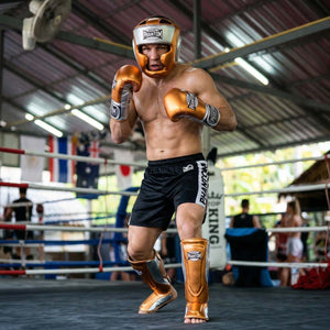 Der Phantom Athletics Schienbeinschutz Mexico in Orange/Silber bietet zuverlässigen Schutz für intensives Training im Muay Thai, Kickboxen und MMA. Die starke Polsterung an Schienbein und Spann absorbiert harte Kicks effektiv und sorgt für sicheres Sparring auf hohem Niveau.