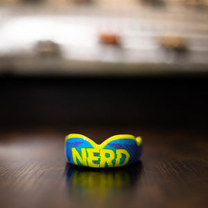 Damage Control Zahnschutz - Nerd mit einzigartigem Design für Kämpfer.
Mit seinem auffälligen Nerd-Design und erstklassigem Schutz ist dieser Zahnschutz eine witzige und funktionale Wahl für alle, die auf der Matte oder im Ring auffallen möchten.