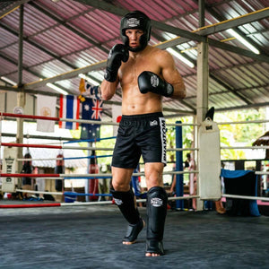 Der Phantom Athletics Schienbeinschutz Mexico in Schwarz bietet zuverlässigen Schutz für intensives Training im Muay Thai, Kickboxen und MMA. Die starke Polsterung an Schienbein und Spann absorbiert harte Kicks effektiv und sorgt für sicheres Sparring auf hohem Niveau.