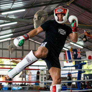 Der Phantom Athletics Schienbeinschutz Mexico in Weiß/Rot/Grün bietet zuverlässigen Schutz für intensives Training im Muay Thai, Kickboxen und MMA. Die starke Polsterung an Schienbein und Spann absorbiert harte Kicks effektiv und sorgt für sicheres Sparring auf hohem Niveau.