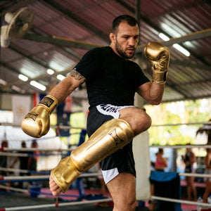 Der Phantom Athletics Schienbeinschutz Mexico in Gold bietet zuverlässigen Schutz für intensives Training im Muay Thai, Kickboxen und MMA. Die starke Polsterung an Schienbein und Spann absorbiert harte Kicks effektiv und sorgt für sicheres Sparring auf hohem Niveau.