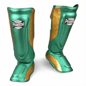 Hochwertige Phantom Athletics Shinpads MEXICO in Grün und Gold, entwickelt für intensives Kampfsport‑Training im Muay Thai, Kickboxen und MMA mit zuverlässigem Schutz bei Kicks, Blocks und Sparring. Die robuste Polsterung und ergonomische Passform sorgen für optimalen Komfort und Sicherheit bei jedem Workout im Gym.