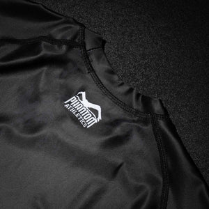 Das Phantom Athletics Rashguard EVO Two in Schwarz ist für höchste Ansprüche im Kampfsport entwickelt worden. Mit seinem körpernahen Sitz, der Muskelunterstützung durch Kompression und dem robusten Funktionsmaterial ist es ideal für MMA, BJJ, Grappling oder funktionelles Krafttraining.