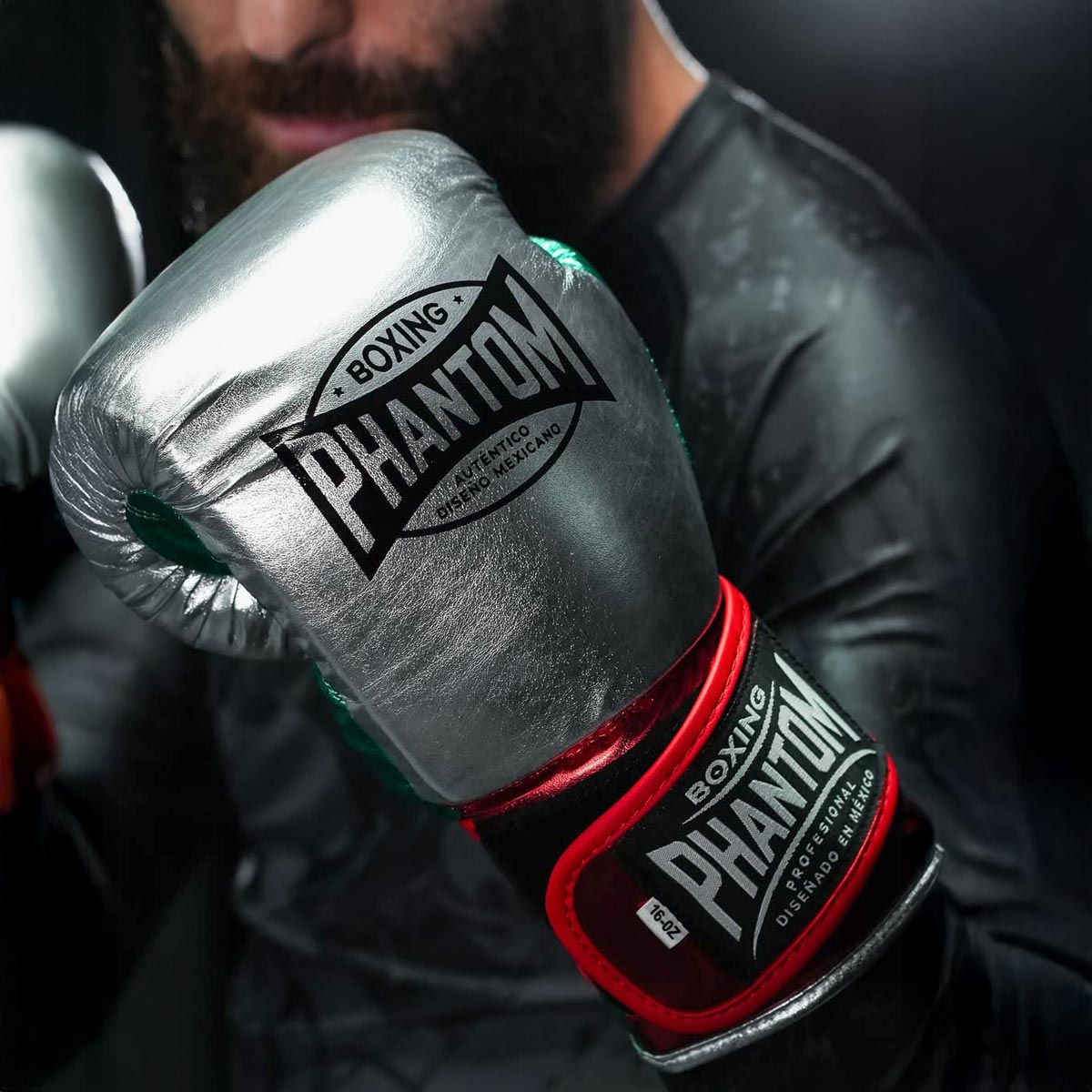 Stylische Phantom Athletics Boxhandschuhe Mexico in edlem Silber mit auffälligen Farbdetails, ideal für tägliche Kampfsport‑Workouts, Fitnessboxen und Sparring. Das robuste PU‑Kunstleder ist langlebig und vegan, während der schlanke Schnitt maximale Kontrolle bei jedem Punch ermöglicht. Ein Premium‑Produkt für ambitionierte Athleten.