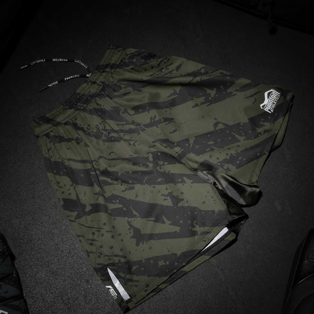 Diese hochwertigen MMA Shorts von Phantom Athletics in Army Tiger Camo setzen ein klares Statement im Training und Wettkampf. Der enganliegende Sitz durch Klettverschluss und Kordelzug sorgt für optimalen Halt, während das atmungsaktive, leichte Material dich bei jeder Kampfsporteinheit unterstützt.