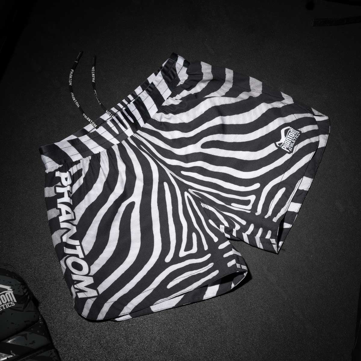 Das Zebra-Design der Phantom Athletics Fusion Shorts steht für Wildheit und Individualität im Kampfsport. Die Shorts bieten durch ihren leichten, atmungsaktiven Stoff und den stabilen Verschluss maximale Performance – perfekt für Fighter, die auffallen und gleichzeitig auf Qualität setzen.