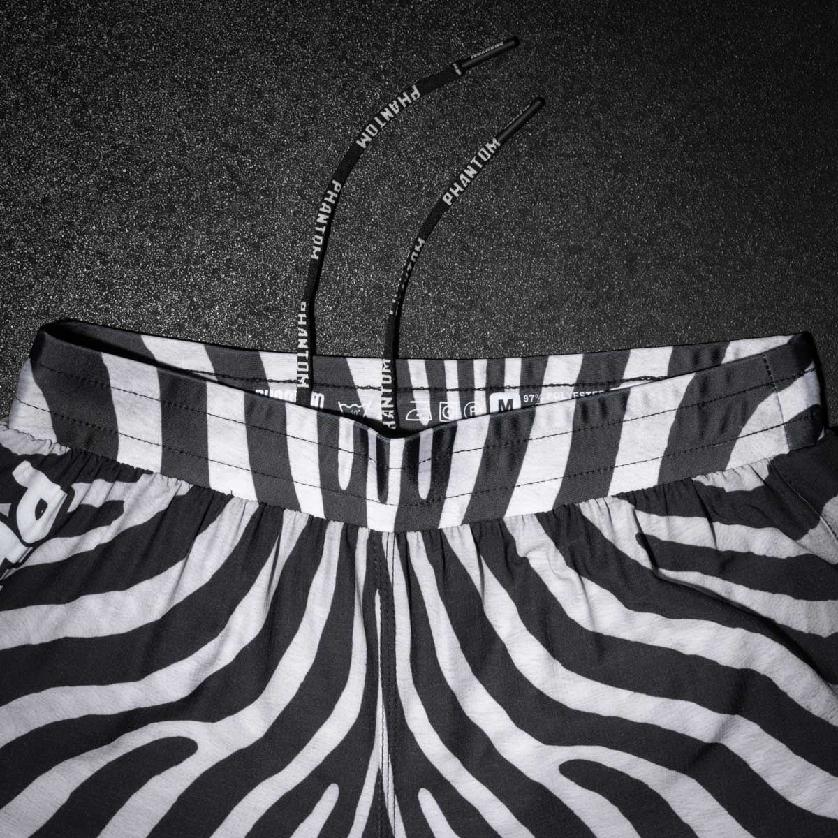 Diese Kampfsport-Shorts von Phantom Athletics im Zebra-Look sind ideal für alle, die beim Training oder Wettkampf auf Komfort, Style und Leistung setzen. Dank des durchdachten Designs bleiben sie auch bei schnellen Bewegungen fest an Ort und Stelle – ohne Verrutschen.