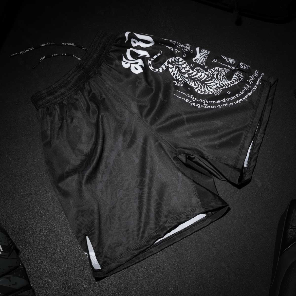 Die Phantom Athletics Fightshorts EVO im Sak Yant Design verbinden thailändische Tradition mit moderner Kampfsport-Performance. Inspiriert von den kraftvollen Muay Thai Tattoos, bieten diese Shorts maximale Bewegungsfreiheit, perfekten Sitz und robustes Material für dein nächstes Training oder den Wettkampf.