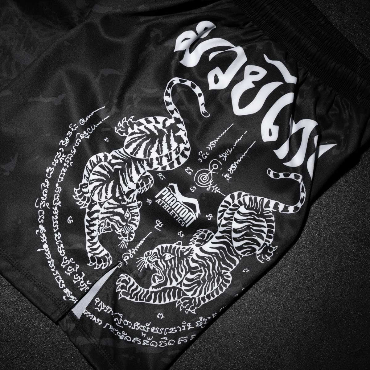 Diese Muay Thai Shorts von Phantom Athletics vereinen das mystische Sak Yant Muster mit hochwertiger Verarbeitung für maximale Leistung im Kampfsport. Ob Sparring oder Fight – die stabile Passform, kombiniert mit leichtem Funktionsstoff, macht diese Shorts zur perfekten Wahl für traditionelle und moderne Kampfsportler.