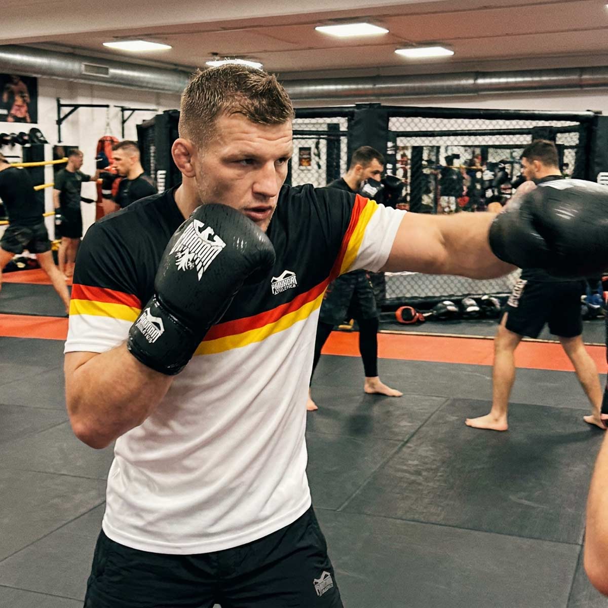 Mit dem Phantom Athletics Training Shirt EVO Germany EC White trainierst du auf höchstem Niveau und profitierst von optimaler Atmungsaktivität und Beweglichkeit. Ideal für Athleten, die hochwertige Fightwear für Boxen, Muay Thai und tägliches Kampfsport-Training suchen.