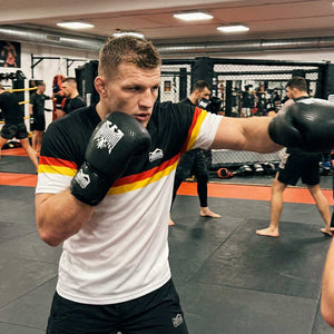 Mit dem Phantom Athletics Training Shirt EVO Germany EC White trainierst du auf höchstem Niveau und profitierst von optimaler Atmungsaktivität und Beweglichkeit. Ideal für Athleten, die hochwertige Fightwear für Boxen, Muay Thai und tägliches Kampfsport-Training suchen.