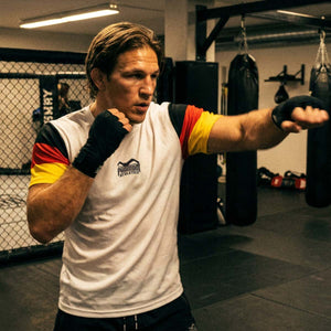 Das Phantom Athletics Training Shirt EVO Team Germany White steht für hochwertige Fightwear und maximale Performance im Kampfsport. Das leichte, elastische Material eignet sich ideal für MMA, Muay Thai, Boxen und funktionelles Training und bietet optimalen Komfort bei intensiven Sparring- und Gym-Sessions.