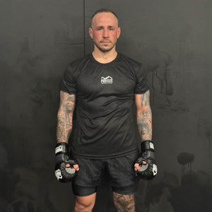 Das Trainingsshirt EVO Aztec von Phantom Athletics kombiniert auffälliges Design mit funktionaler Performance. Der Azteken-Print auf der Vorderseite und das atmungsaktive MXP-Tech-Material machen es zum idealen Begleiter für intensives MMA-, Box- oder Kickbox-Training.