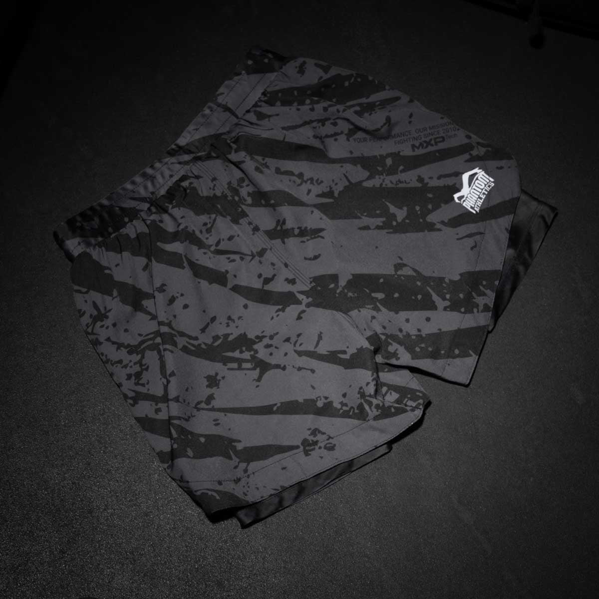 Phantom Athletics Kampfsport-Shorts im 2in1-Design mit modernem Tiger-Camo-Look, perfekt für Sparring, Takedowns und intensive Workouts. Die Kombination aus Außen-Short und Compression Layer sorgt für maximale Performance.