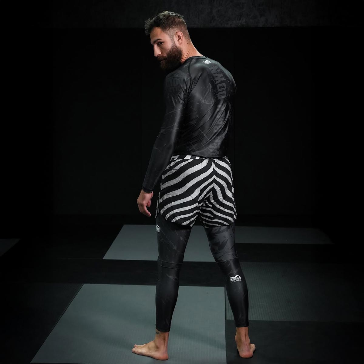 Premium Phantom Athletics Rashguard Germany Longsleeve für MMA, Jiu‑Jitsu und Grappling, aus elastischem, atmungsaktivem Material für optimale Bewegungsfreiheit und Komfort bei Technik‑Drills und Sparring. Das enganliegende Design schützt die Haut vor Reibung auf der Matte und sorgt für Performance und Langlebigkeit bei intensiven Trainingseinheiten. Ein hochwertiges Kampfsport‑Shirt für ambitionierte Athleten.