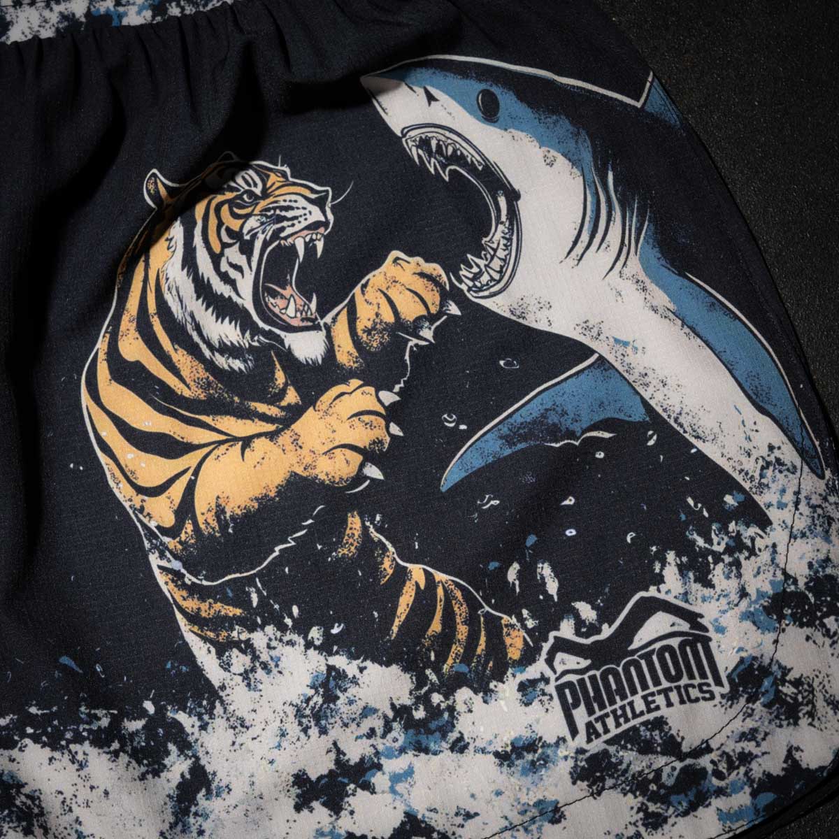 Die Phantom Athletics Fightshorts Fusion-R Tiger vs. Shark kombinieren modernes Design mit maximaler Funktionalität. Das auffällige Tiger- und Hai-Motiv macht sie zu einem echten Highlight im MMA-Training.