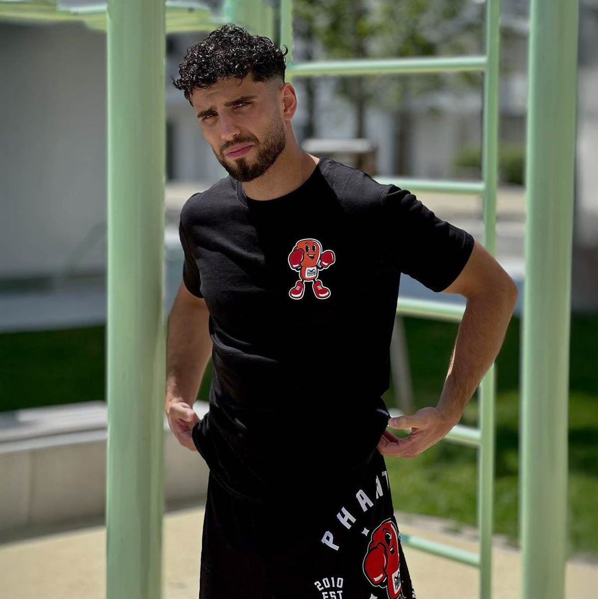 Phantom Athletics T‑Shirt „Punchy“ in Schwarz – stylisches Baumwollshirt mit auffälligem „Punchy“-Print auf der Brust und Rücken, ideal für Kampfsporttraining und Streetwear.