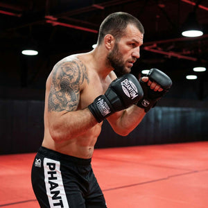 Die Phantom Athletics MMA Sparring Gloves Mexico in Schwarz bieten optimalen Schutz und volle Bewegungsfreiheit für intensives MMA, Grappling und Sparring. Das offene Handdesign ermöglicht präzise Clinch- und Bodentechniken, während die starke Polsterung deine Hände bei harten Schlagkombinationen zuverlässig schützt.
