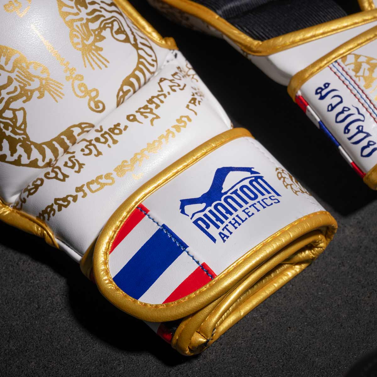 Phantom Muay Thai Handschuhe für Thaiboxen und MMA Sparring, Wettkampf und Training. Im traditionellen Sak Yant Design und der Farbe Weiß/Gold.