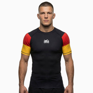 Der Phantom Athletics Rashguard Germany in Black/Red/Gold ist ein hochwertiger Kurzarm Rashguard für MMA, Grappling und BJJ Training. Das Kompressionsmaterial sorgt für optimalen Halt, Schutz vor Reibung und maximale Bewegungsfreiheit im Kampfsport.