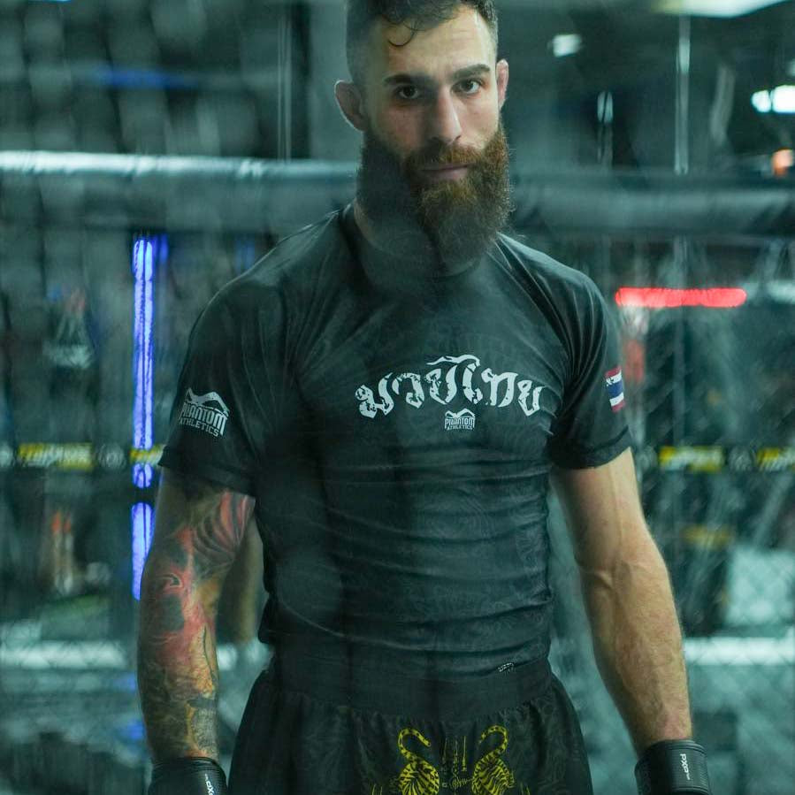 Das schwarze Phantom Athletics Muay Thai Rashguard kombiniert traditionelle thailändische Sak-Yant-Motive mit funktionellem Compression Fit. Atmungsaktives 4-Wege-Stretch-Material bietet maximale Bewegungsfreiheit und eignet sich ideal für Muay Thai, MMA, Grappling und intensives Kampfsporttraining.