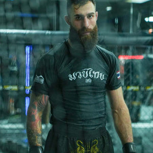 Das schwarze Phantom Athletics Muay Thai Rashguard kombiniert traditionelle thailändische Sak-Yant-Motive mit funktionellem Compression Fit. Atmungsaktives 4-Wege-Stretch-Material bietet maximale Bewegungsfreiheit und eignet sich ideal für Muay Thai, MMA, Grappling und intensives Kampfsporttraining.