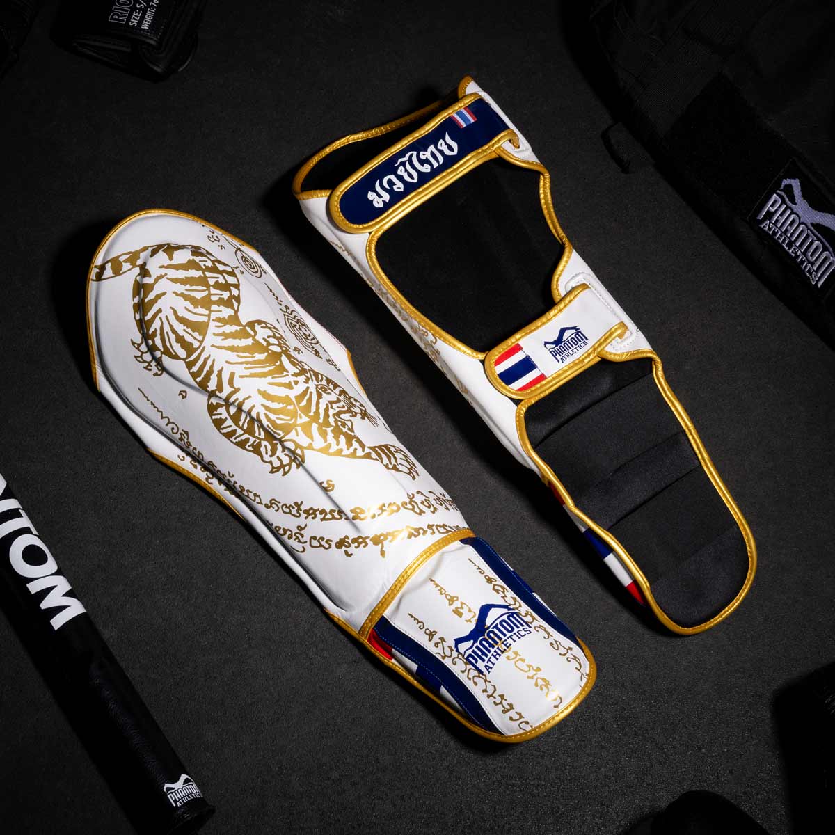Phantom Muay Thai Schienbeinschutz für Thaiboxen und MMA Sparring, Wettkampf und Training. Im traditionellen Sak Yant Design und der limitierten Farbe Weiß/Gold.