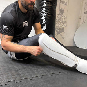 Weißer Schienbeinschoner Phantom Athletics „Muay Thai Frost White“ mit extra dicker Polsterung – ideal für MMA, Muay Thai und Kickboxtraining. Bietet zuverlässigen Schutz bei Lowkicks und Knieattacken.