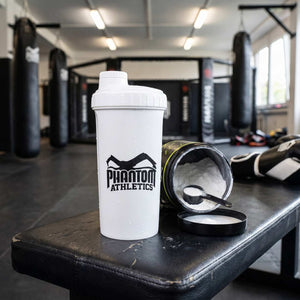Mit dem weißen Phantom Athletics „Earned. Not Given.“ Shaker lassen sich Proteinshakes und Sportgetränke bequem zum Kampfsporttraining mitnehmen. Das markante Statement steht für Disziplin, harte Arbeit und einen leistungsorientierten Fighter-Lifestyle.