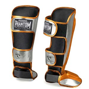Premium Kampfsport Schienbeinschützer von Phantom Athletics in leuchtendem Orange und Silber, entwickelt für harte Trainingseinheiten und Technikworkouts im MMA oder Kickboxen. Die ergonomische Passform und sicheren Klettverschlüsse sorgen für stabilen Halt, Schutz und Komfort bei jedem Training.