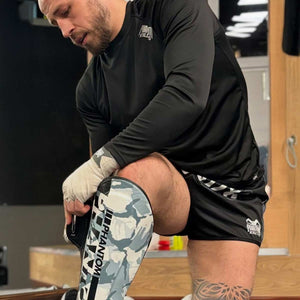 Die Apex Striking Whiteout Schienbeinschoner von Phantom Athletics bieten optimalen Schutz bei harten Low Kicks und intensiven Sparringseinheiten. Dank extra dicker Polsterung der Kick-Fläche, zusätzlicher Polsterung des Vorderfußes und einem elastischen Band sorgen sie für einen perfekten Halt während des Trainings.