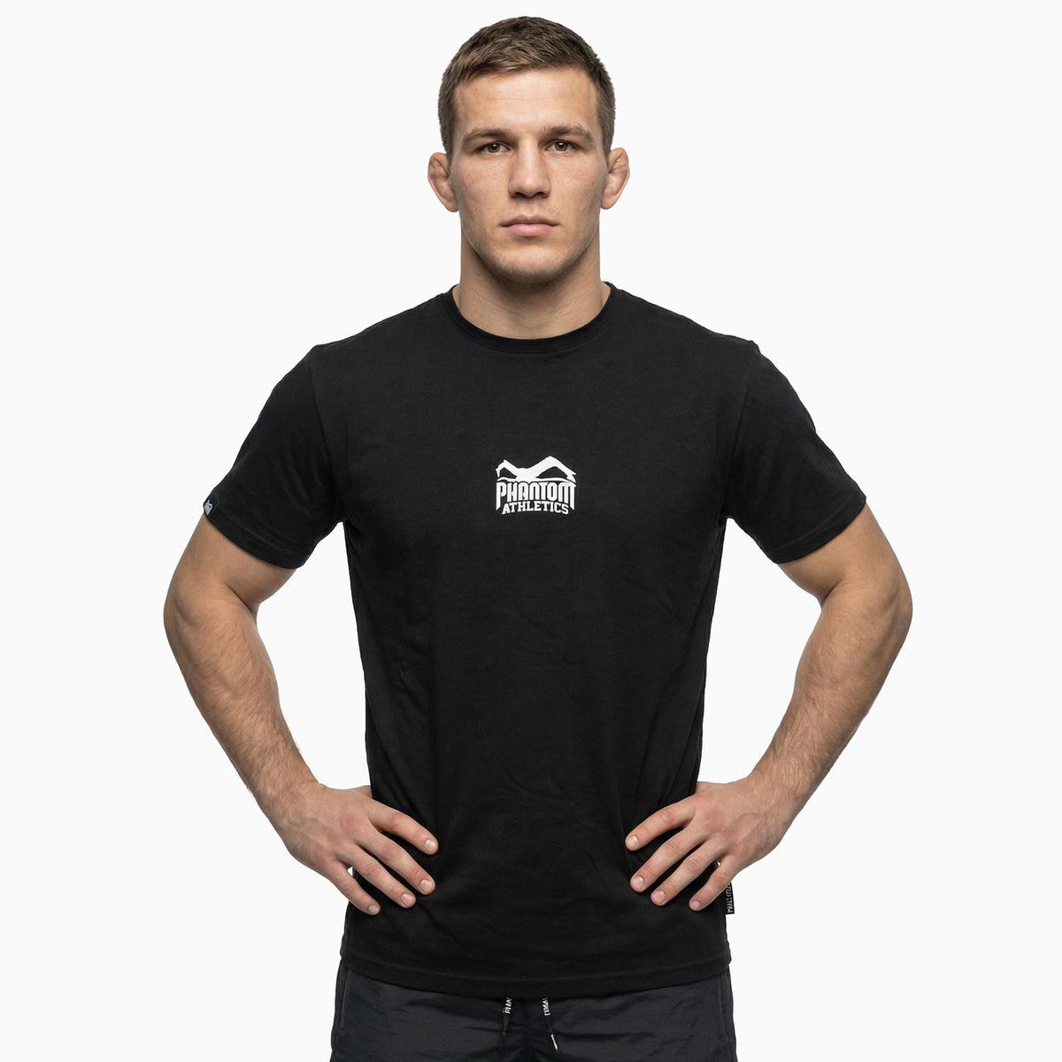 Phantom Athletics Team T‑Shirt in Schwarz mit sportlichem Print, aus atmungsaktivem Material für MMA‑Training, Box‑Warm‑ups und tägliche Fitness‑Sessions.