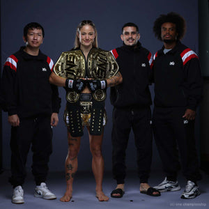 Die Phantom Athletics Trainingsjacke DMC Team Austria kombiniert schwarzen Retro-Style mit markanten rot-weiß-roten Ärmeln im Österreich-Look. Leichtes Performance-Material und Mesh-Innenfutter bieten hohen Komfort für MMA, Boxen, Muay Thai, Warm-up und Freizeit.